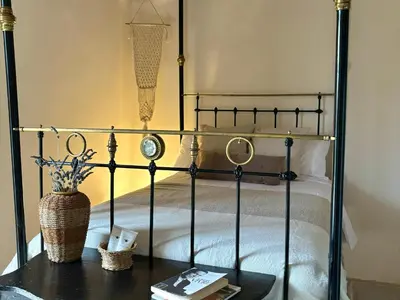 a black bed with a vase on a table at Levanda House - Traditional House Vasa Koilaniou in Vasa Kilaniou