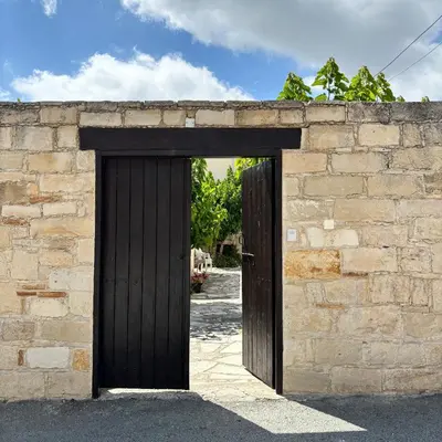 a wooden door opening into a stone wall at Levanda House - Traditional House Vasa Koilaniou in Vasa Kilaniou