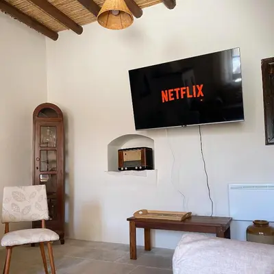 a living room with a tv on the wall at Levanda House - Traditional House Vasa Koilaniou in Vasa Kilaniou