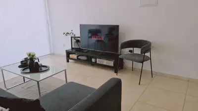 a living room with a tv and a couch and a table at STAY Novel Apartment in Larnaka
