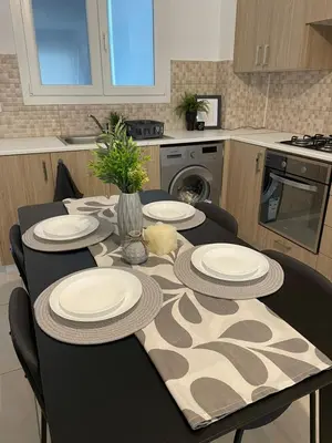 a table with plates on it in a kitchen at STAY Novel Apartment in Larnaka