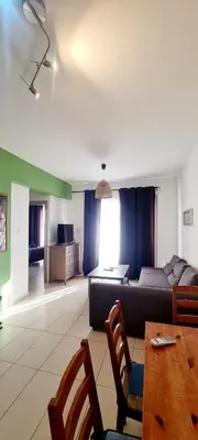 a living room with a couch and a table and chairs at Crystal aptmnt next to the beach in Protaras