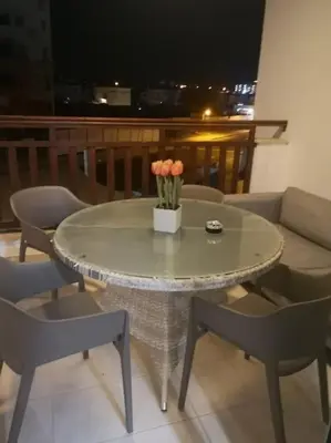 a table with a vase of flowers on a balcony at Crystal aptmnt next to the beach in Protaras