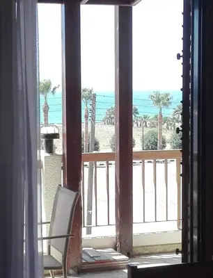 a room with a view of the ocean from a balcony at Sweet Home by the sea in Pyla