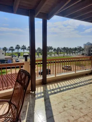 a chair on a porch with a view of a highway at Sweet Home by the sea in Pyla