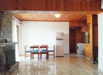 a kitchen and dining room with a table and a refrigerator at Sweet Home by the sea in Pyla