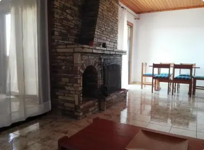 a brick fireplace in a living room with a table at Sweet Home by the sea in Pyla