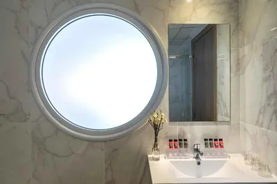 a bathroom with a sink and a round window at Cyprotel Florida in Ayia Napa