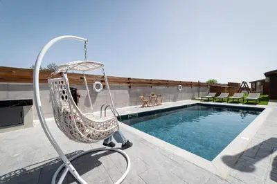 a person sitting in a swing by a swimming pool at Ktima To Alliotiko - Lofou 2 in Lofou