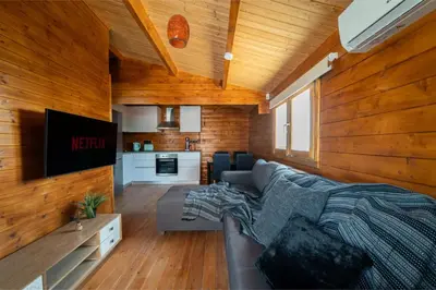 a living room with a couch and a tv at Ktima To Alliotiko - Lofou 2 in Lofou