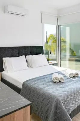 a bedroom with a large bed with towels on it at Villa Elite Blu by Ezoria Villas in Ayia Napa