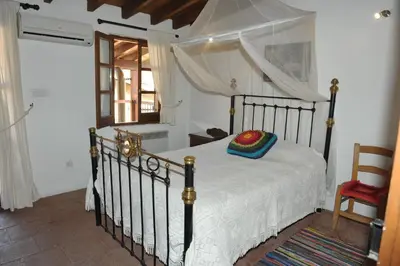 a bedroom with a bed and a chair and a window at Zangoulos Villa in Kakopetria