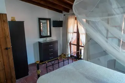 a bedroom with a bed and a dresser and a window at Zangoulos Villa in Kakopetria