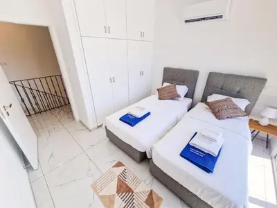 a room with two beds and a table at Sunshine Villa Ayia Napa in Ayia Napa