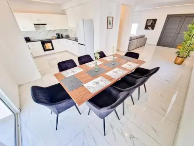 a dining room with a wooden table and chairs at Sunshine Villa Ayia Napa in Ayia Napa
