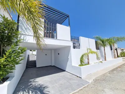 a house on the beach with white walls and palm trees at Sunshine Villa Ayia Napa in Ayia Napa