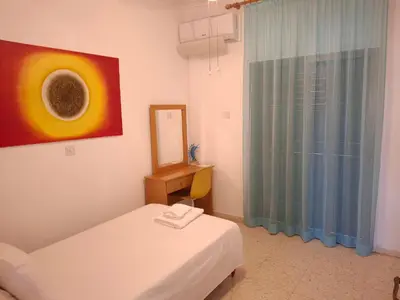 a room with two beds and a mirror and a window at Grandma's House in Liopetri