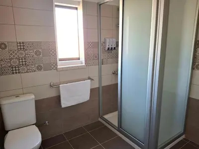 a bathroom with a toilet and a glass shower at Grandma's House in Liopetri
