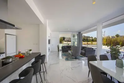 a kitchen and living room with a table and chairs at Brand New Luxurious Villa With Pool in Protaras