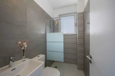a bathroom with a toilet and a sink and a window at Brand New Luxurious Villa With Pool in Protaras