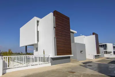 a white building with a brown and white wall at Brand New Luxurious Villa With Pool in Protaras