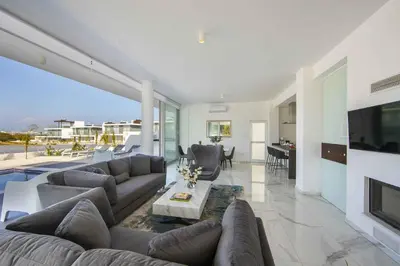 a living room with a couch and a table and a tv at Brand New Luxurious Villa With Pool in Protaras