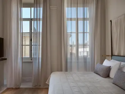 a bedroom with a bed and large windows at Amyth of Nicosia in Nicosia