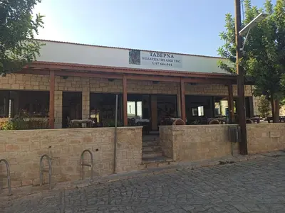 a restaurant with a brick building with windows at Cottage in Anogyra in Anoyira