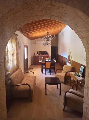 a living room with an archway with a table and chairs at Cottage in Anogyra in Anoyira