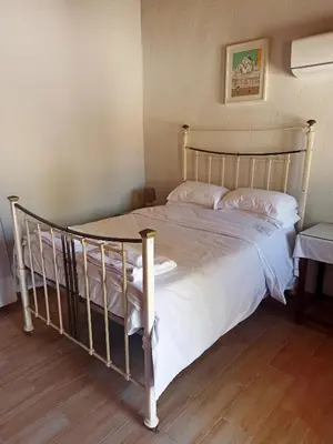 a bedroom with a large bed with white sheets at Cottage in Anogyra in Anoyira