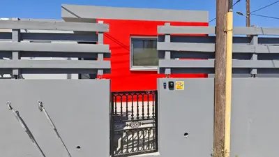 a red building with a refrigerator and a pole at Modern 1-bedroom home in Larnaca with a private garden ideal for long stays and remote work in Larnaka