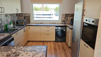 a kitchen with a washer and dryer in it at Modern 1-bedroom home in Larnaca with a private garden ideal for long stays and remote work in Larnaka
