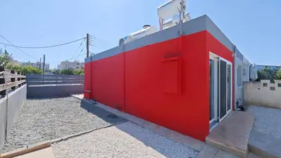 a red building on the side of a building at Modern 1-bedroom home in Larnaca with a private garden ideal for long stays and remote work in Larnaka
