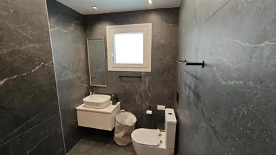 a bathroom with a toilet and a window at Modern 1-bedroom home in Larnaca with a private garden ideal for long stays and remote work in Larnaka