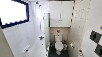 a small bathroom with a toilet and a shower at Boho Greek Haven with Orange Grove Views Near Beach in Larnaka