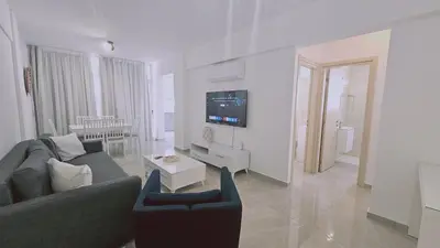 a living room with a couch and a tv at STAY Local Apartment in Larnaka