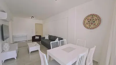 a living room with a white table and a couch at STAY Local Apartment in Larnaka