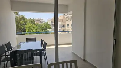 a dining room with a table and chairs and a window at STAY Local Apartment in Larnaka