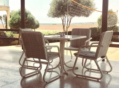 a table and three chairs and a table and a table at Ayia Napa - Ayia Thekla Sea View Beach Villa in Ayia Napa