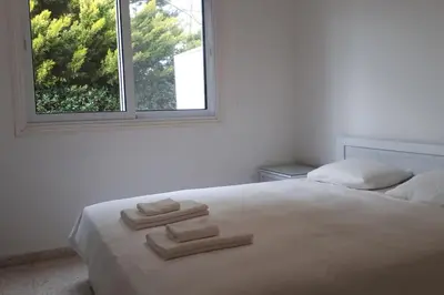 a white bed with three towels on it in front of a window at Ayia Napa - Ayia Thekla Sea View Beach Villa in Ayia Napa
