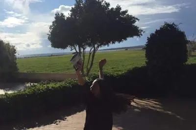 a girl holding up a kite in front of a tree at Ayia Napa - Ayia Thekla Sea View Beach Villa in Ayia Napa