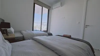 a bedroom with two beds and a large window at STAY Diamond Apartment in Larnaka