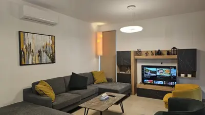 a living room with a couch and a tv at STAY Diamond Apartment in Larnaka