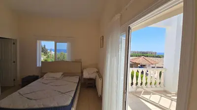a bedroom with a bed and a view of a balcony at Villa Dafni Malama in Paralimni