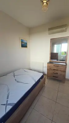 a bedroom with a bed and a dresser and a window at Villa Dafni Malama in Paralimni
