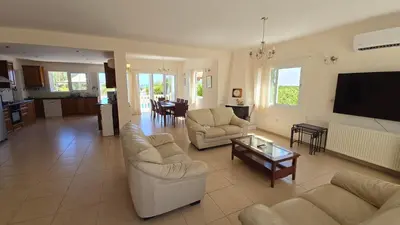 a living room with couches and a tv and a table at Villa Dafni Malama in Paralimni