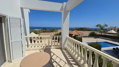 a balcony with a table and a view of the ocean at Villa Dafni Malama in Paralimni