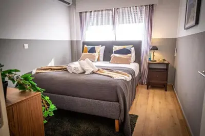 a bedroom with a large bed with a window at Stylish Newly Renovated Flat, 250 Meters from the Beach, Central Location with Free Parking in Limassol