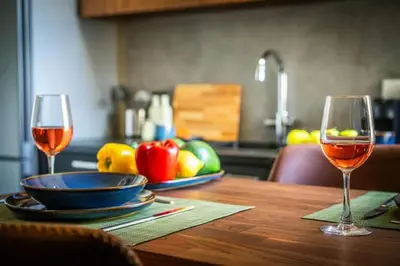 two glasses of wine sitting on a wooden table at Stylish Newly Renovated Flat, 250 Meters from the Beach, Central Location with Free Parking in Limassol