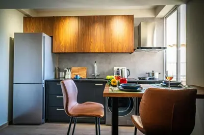 a kitchen with a table and chairs and a refrigerator at Stylish Newly Renovated Flat, 250 Meters from the Beach, Central Location with Free Parking in Limassol